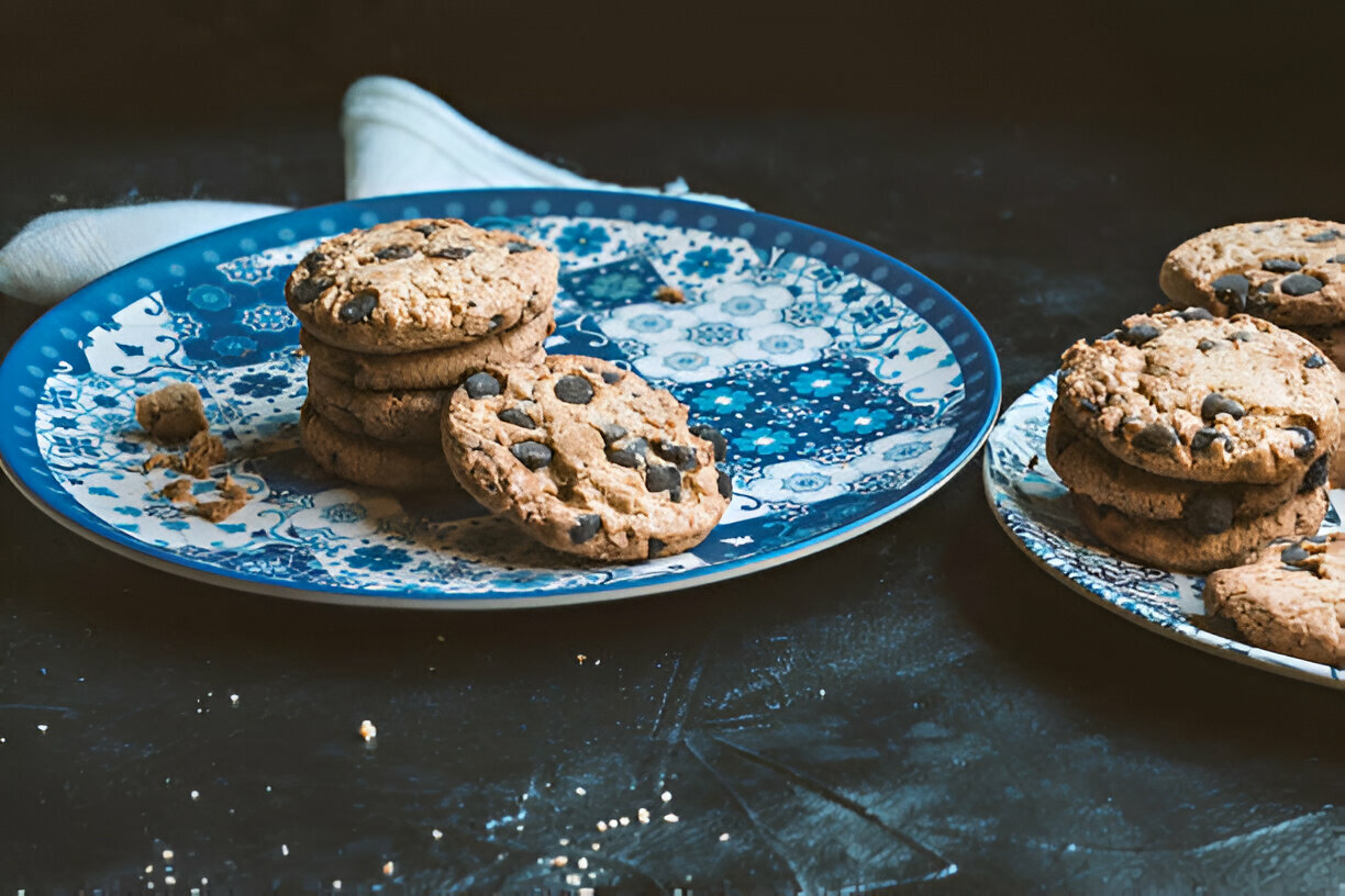 Freshly baked Nestle Toll House chocolate chip cookies cooling on a wire rack, showcasing golden edges and gooey chocolate morsels.